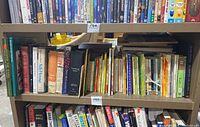 Books arranged on shelf with various titles and genres visible.