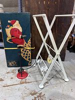 Side view of metal balancing Santa figurine showing detailed paint and gifts in sack.