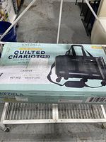 Photo of the original box showing Katziela branding, Quilted Chariot Pro model, airline approved label, color Black.