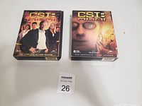 Two DVD box sets for CSI Miami seasons 2 and 3 placed side by side on a white surface with a maxsold lot number card in front.