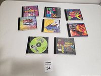 Photo of 8 dance music CDs arranged on a white surface showing front covers and discs.