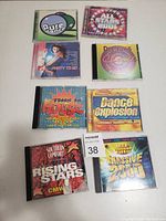Photo of seven dance music CDs in jewel cases with colorful graphic covers.