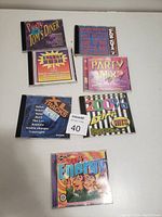 Seven dance music CDs with colorful cover art showing titles and themes involving dance and party mixes.