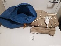 Heat up blanket folded on floor next to a blue cushion or cover.