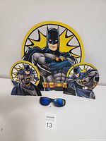Close-up of the three Batman themed cardboard decorations with black, yellow and white pop art style background.