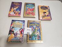 Photo showing five Disney VHS tapes: Beauty and the Beast, The Little Mermaid, The Hunchback of Notre Dame, Sleeping Beauty, and Peter Pan.
