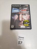 Front view of the PlayStation 2 WWE SmackDown vs Raw game case showing cover art and rating.