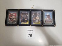 Front side of four vintage race car cards in a black holder, featuring Dale Earnhardt, Richard Petty, Bill Elliott, and Tide card.