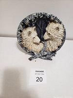 Front view of the wolf collectible plate showing detailed 3D sculpted wolves facing each other with textured background.