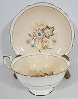 Paragon tea cup and saucer set shown front and centered, highlighting floral design and gold trim