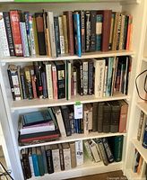 Image of a bookshelf containing a variety of hardcover and paperback books along with some DVDs, showing titles relating to classic literature and non-fiction subjects.