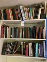Shelf showing a variety of textbooks on mathematics, physics, and general science topics, mixed with some hardcover and softcover books.