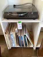 Turntable on top shelf with books below, showing overall lot setup