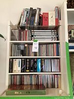 Shelf with multiple rows of CDs and DVDs organized showing various classical and musical titles and boxed sets.