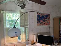 Full view of arc floor lamp installed over wooden table