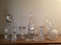 Full lot showing all cut glass items arranged on table against wall