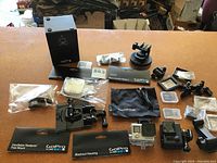 Full lot display showing all contents including GoPro cameras, various mounts, adapters, blackout housing, and packaging boxes.