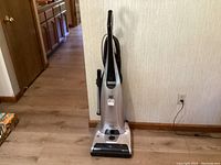 Full frontal image of the silver Kenmore Elite upright vacuum cleaner showing the body with handle and cord wrapped at the back.
