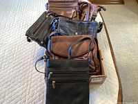 Top view of six ladies cross body bags stacked, showing variances in color and style