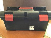 Closed black Rubbermaid toolbox with red latches and handle