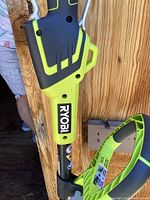 Close-up photo of green and black Ryobi edger tool with logo visible on shaft