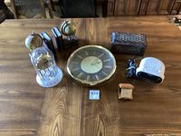 Overview showing large wall clock, vintage bedside alarm clock, Sony digital alarm clock, globe bookends with matching wooden box, and small gold-tone travel alarm clock.