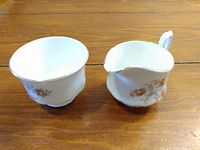 Bone China Cream Pitcher and Sugar Bowl set placed side by side on a wooden surface