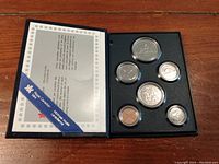 Full set of six coins in original display case showing certificate of authenticity.