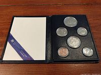 The full set of six coins displayed in a black folder, showing their arrangement and protective case.