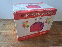 Image of the electric balloon pump's original box showing front and sides with model number and balloon graphics.