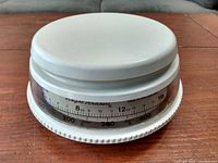 White round mechanical kitchen scale with dial measurement, made in Switzerland, showing grams and ounces.