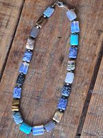 Full view of the multi gemstone rectangle bead necklace laid flat showing varied rectangular beads and clasp.