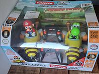 Boxed set of Carrera Mario Kart remote control cars with Mario and Yoshi characters.