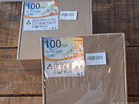 Two cardboard boxes, each labeled as containing 100 tea light candles, sealed and unopened.