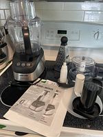 Black & Decker food processor assembled on kitchen counter with bowl, lid, accessories and manual visible