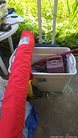 Large red umbrella in protective bag with label showing use in outdoor patio settings.