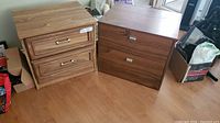 Two wooden bedside tables/end tables side by side showing different handle styles and wood finishes.