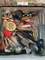 Full drawer view of kitchen utensils including whisks, ladles, spatulas, and other assorted tools