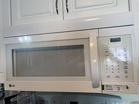 White LG under cabinet mount microwave oven showing front view with door and handle