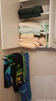 Photo of two large folded colorful beach towels hanging on towel bar.