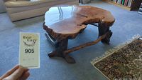 View of coffee table top showing natural wood slab with glossy finish and organic edges.