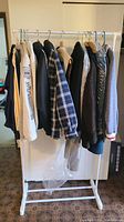 Clothing rack with nine men's clothing items in medium size including jackets, sweaters, and shirts
