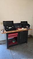 Full view of the metal workbench with wooden top and toolboxes on top