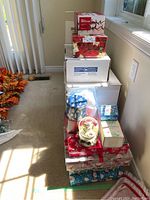 Stack of Christmas-themed boxes and decorative tins with snow globe on top.