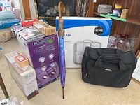 Likewise box fan, Remington foot spa, Body Innovations pillow, weights, umbrella, and bag arranged on floor