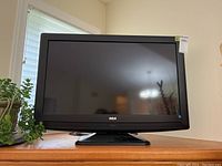 Front view of RCA 32-inch television on stand with screen off.
