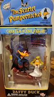 Front view of the figure in original packaging showing Daffy Duck as The Scarlet Pumpernickel with accessories and scene setup.