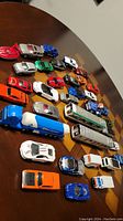 Top-down view of entire lot showing multiple diecast vehicles including cars, trucks, bus, and train car