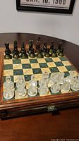 Photo showing the full chessboard with black and clear frosted chess pieces arranged ready to play.