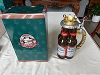 Photo of the Anheuser-Busch 2001 Members Only Stein showing the stein next to its original green box with Collector's Club logo.